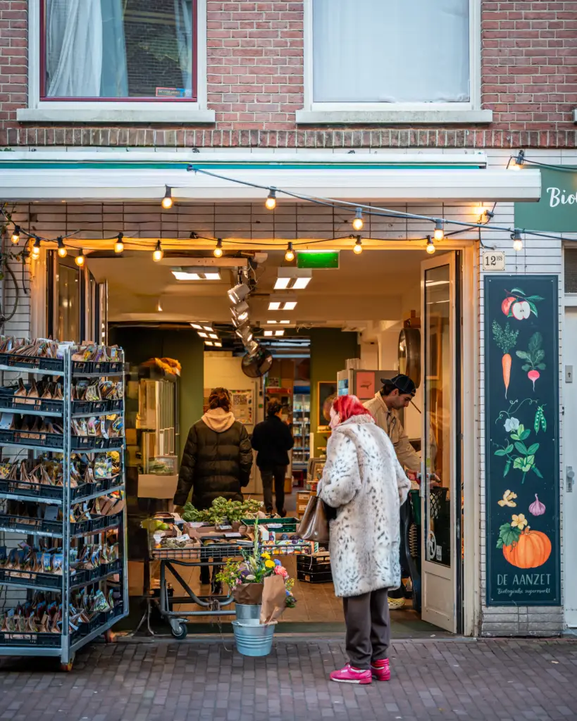 De hoofd ingang van De Aanzet. Hier sta je meteen op de groenten afdeling. Je ziet hier ook wat klanten winkelen.